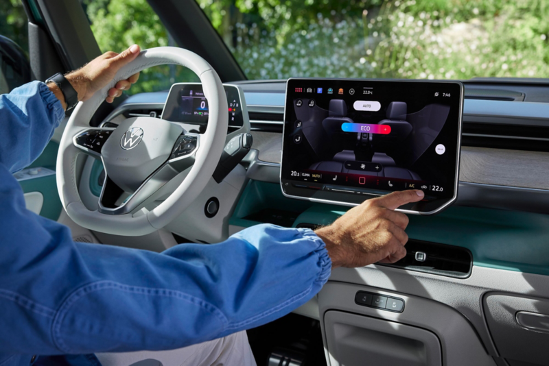 El VW Nuevo California aparcado en la orilla junto a dos personas.