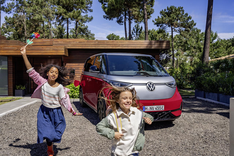 Deux femmes regardant un smartphone dans une VW avec la porte conducteur ouverte – Divertissement et électronique