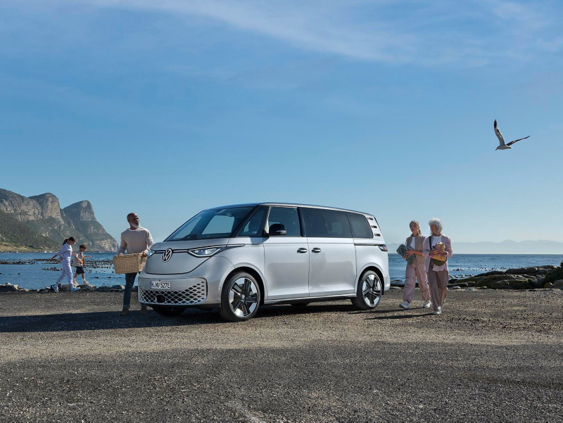 El VW Nuevo California aparcado en la orilla junto a dos personas.