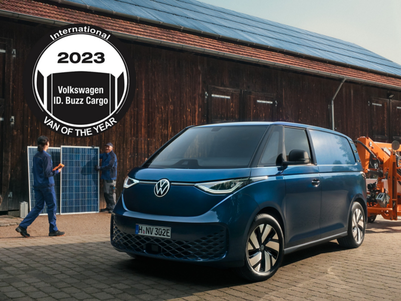 VW ID. Buzz Cargo vor einer Scheune. Darüber das Logo des Award "International Van of the Year 2023".