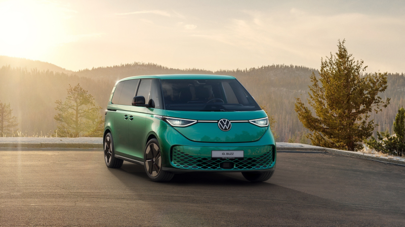 Ein parkender grüner VW ID. Buzz, im Hintergrund eine Berglandschaft.