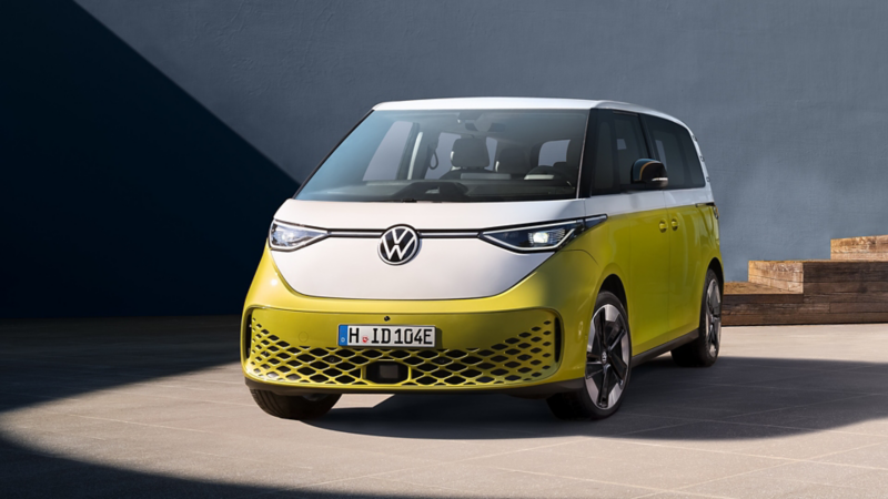 VW ID. Buzz im Halbprofil vor einer grauen Wand.
