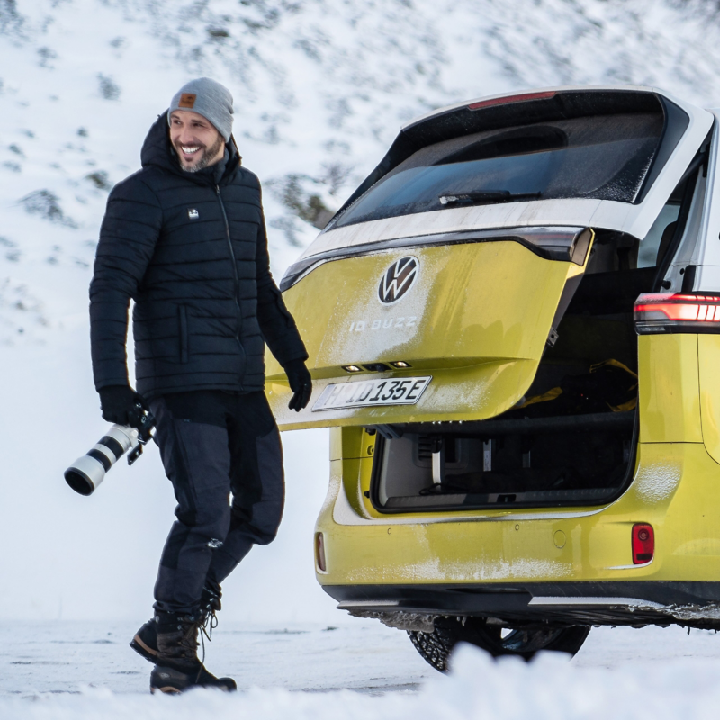 Benjamin Jaworskyj an der geöffneten Heckklappe des VW ID. Buzz in einer verschneiten Gegend.