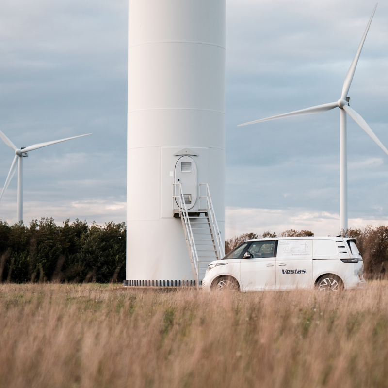 ID.Buzz Cargo steht vor der Windkraftanlage.