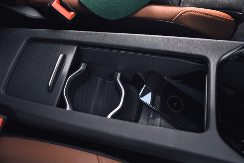 Detailansicht der Mittelkonsole im VW ID.4. Ein Smartphone lädt über die induktive Ladefunktion. 