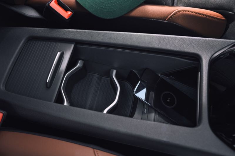 Detailansicht der Mittelkonsole im VW ID.4. Ein Smartphone lädt über die induktive Ladefunktion.