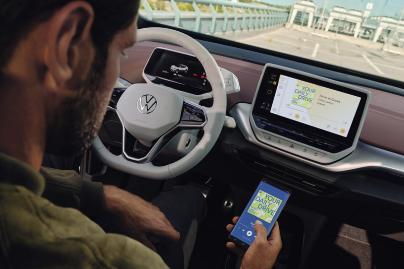 Detailed view of a white multifunction steering wheel in the VW ID.4 with view of speedometer. 