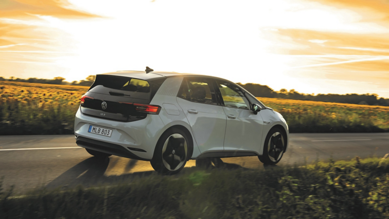 Vit Volkswagen ID.3 kör på en väg förbi ett rapsfält.