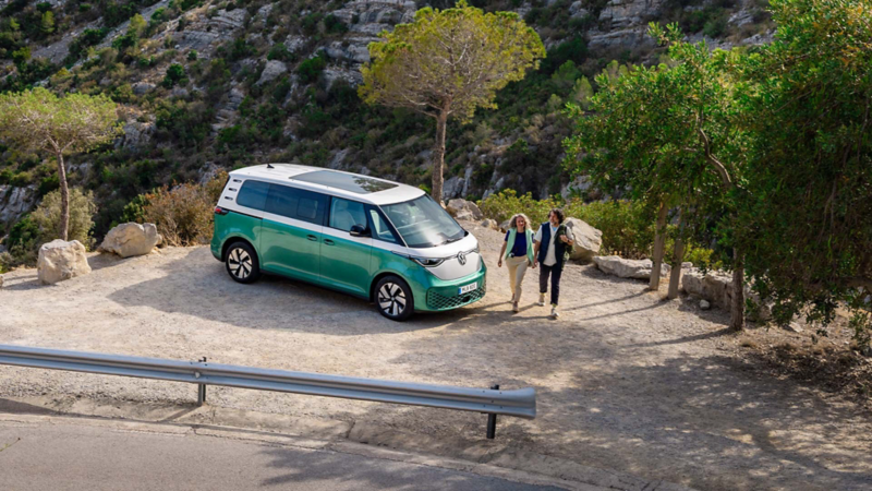 En vit och grön VW ID. Buzz står parkerad på en rastplats