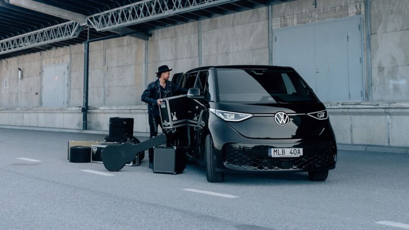 En man packar in sina instrument i en VW ID. Buzz Cargo Sweden Rock Edition