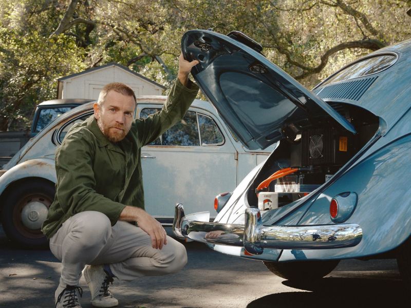 Ewan McGregor neben einem elektrifiziertem VW Käfer.