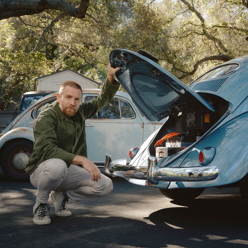 Ewan McGregor à côté d’une VW Coccinelle électrifiée.