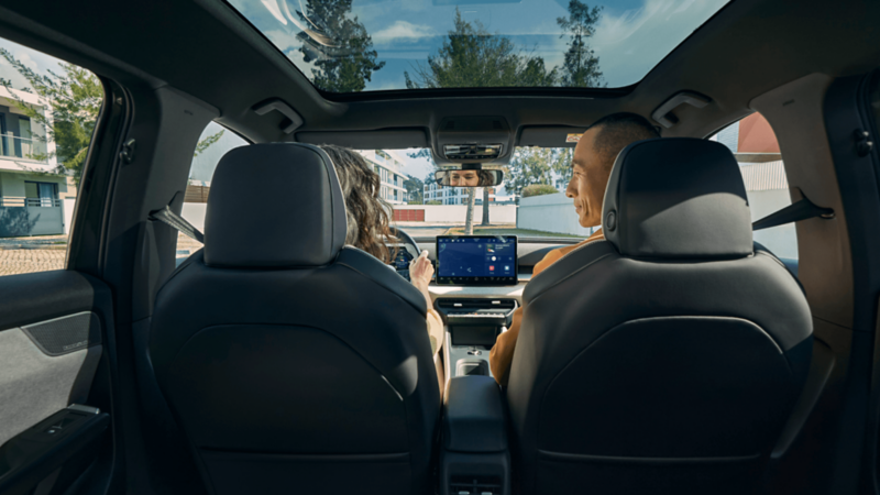 A woman and man are in the front seats of a VW ID. Cross