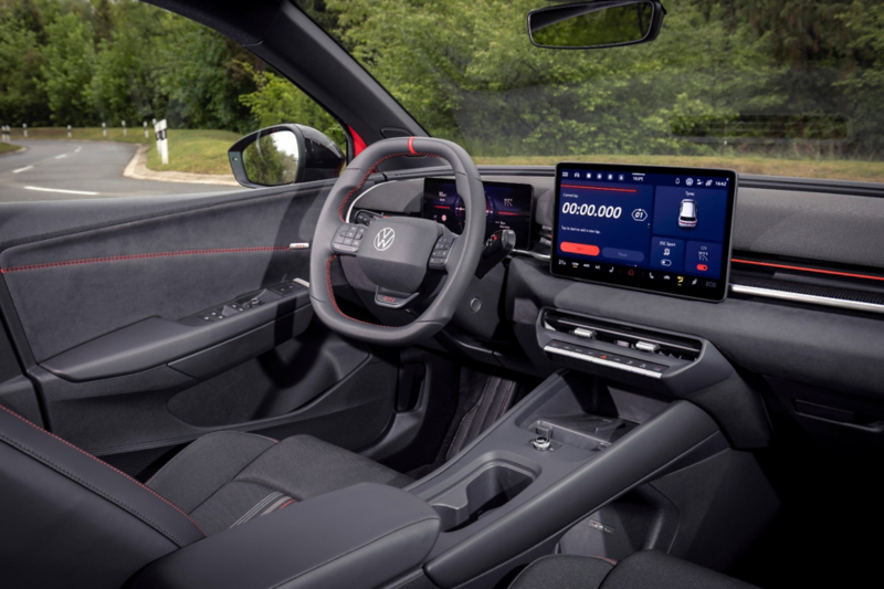 Interior view of a Volkswagen ID. Polo GTI showing the modern dashboard, flat-bottom steering wheel with red stitching, a digital instrument cluster, and a large central touchscreen display.