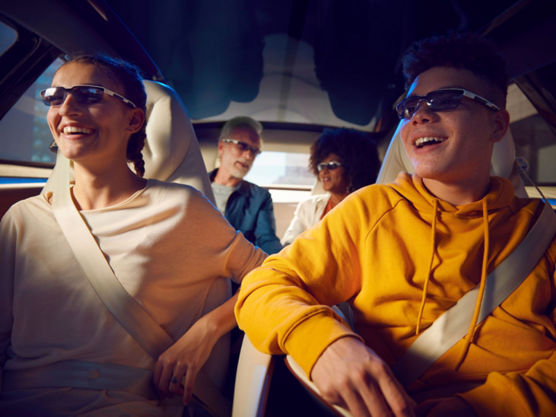 Passagiere mit Mixed-Reality-Brillen im  ID. Vizzion