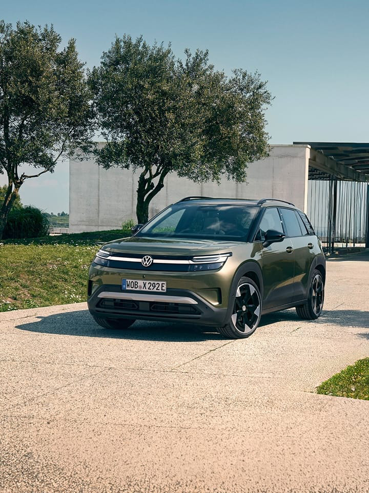 Volkswagen ID. Cross verde visto de frente delante de una casa de diseño contemporáneo