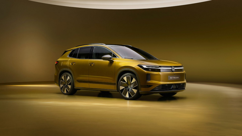 Volkswagen ID. Tiguan in Gold aus schräger Frontansicht vor goldenem Studiohintergrund.