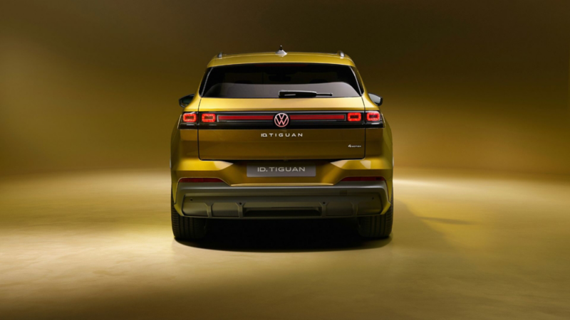 Heckansicht des goldfarbenen Volkswagen ID. Tiguan mit LED-Leuchtenband und beleuchtetem Volkswagen Logo.