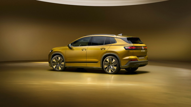 Volkswagen ID. Tiguan in Gold aus schräger Heckansicht vor goldenem Studiohintergrund.