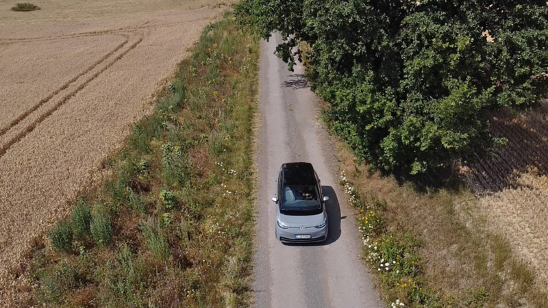 ID.3 fährt auf einen Weg zwischen Felder