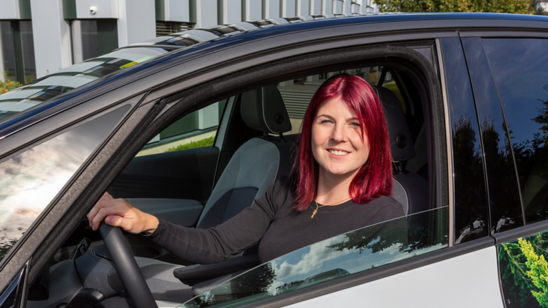 Stefanie Bürge sitzt im ID.3 hinter dem Steuer und schaut aus dem offenen Fenster