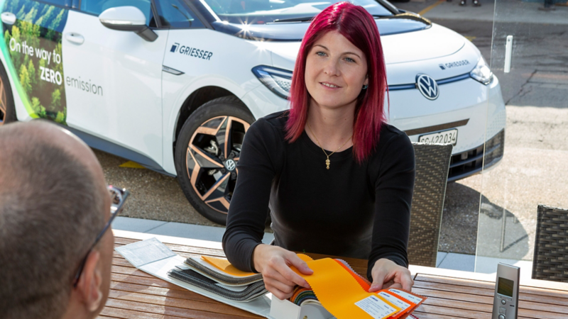 Stefanie Büge zeigt einem Kunden verschieden Farben und Stoffe