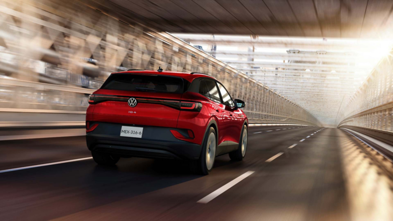 Vista trasera de un Volkswagen ID.4 rojo que avanza por un túnel iluminado.
