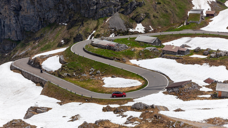 Von weitem sieht man den ID.4 GTX die engen Kurven auf dem Klausenpass fahren