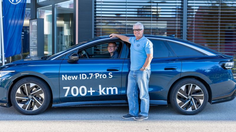 Felix Egolf steht vor dem ID.7 Pro S während Reto darin sitzt