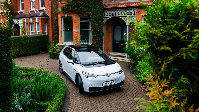 A white Volkswagen ID.3 parked in front of a house