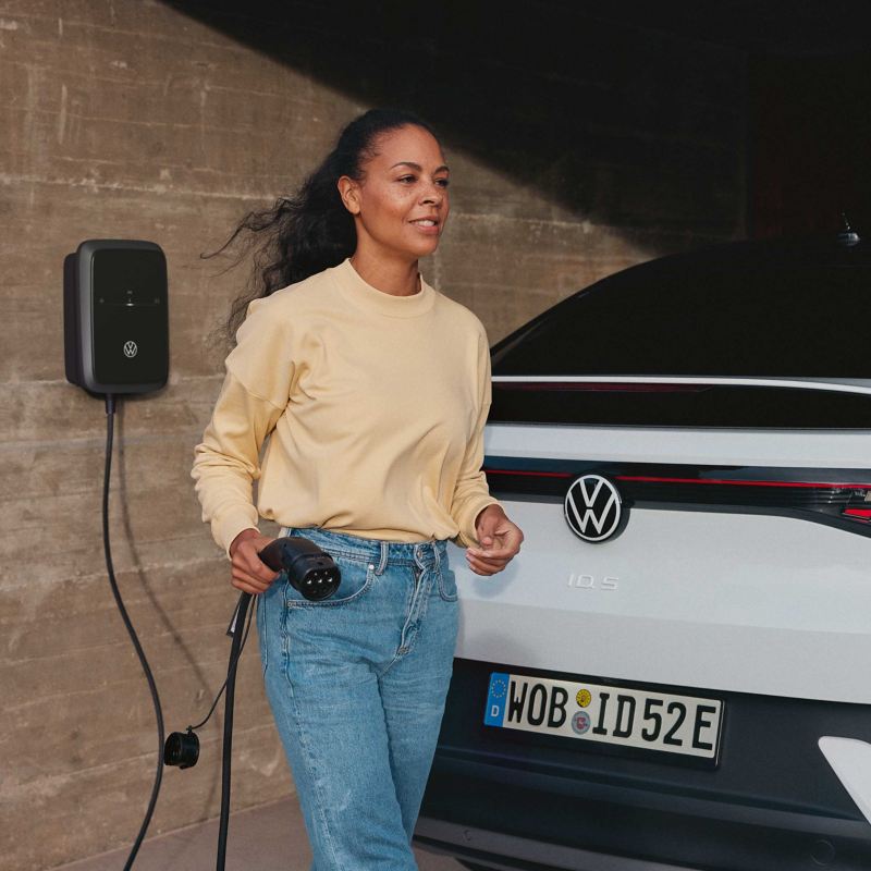  A woman holding a charging plug at the back of an ID.5