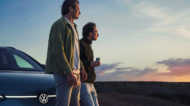 Two people leaning on the bonnet of a VW ID.7 Tourer