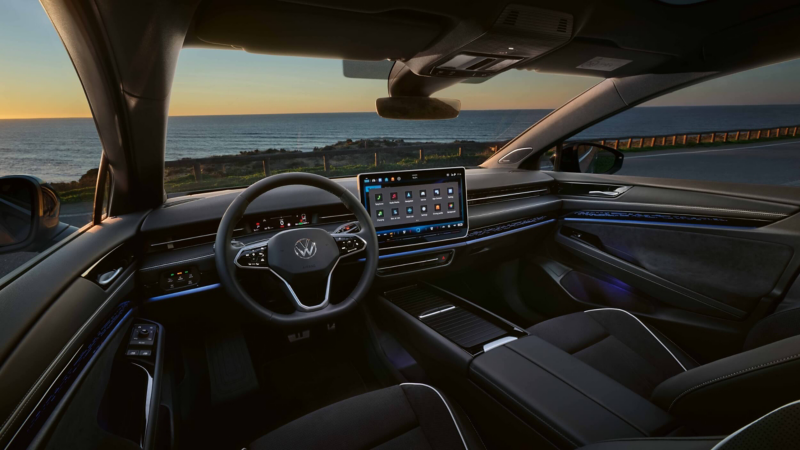Interior of a VW ID.7 Tourer displaying the steering wheel, dashboard, infotainment screen and ambient lighting