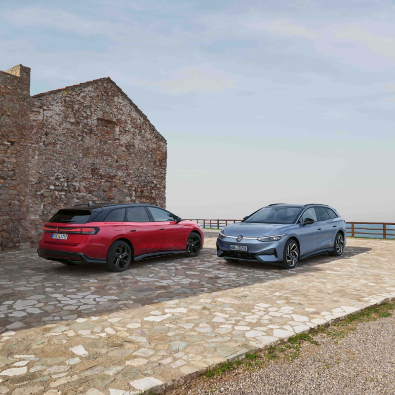 Two ID.7 Tourer cars parked on a coastal mosaic patterned car park