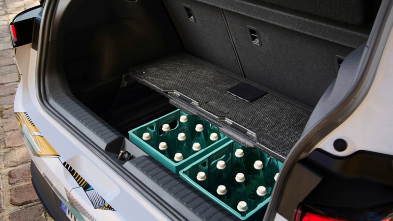 Kofferraum eines Volkswagen ID. Polo mit geöffnetem Ladeboden, darunter Getränkekisten verstaut.