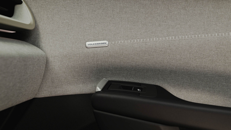 Detailaufnahme der Stoffverkleidung im Innenraum des Volkswagen ID. Polo mit Volkswagen Schriftzug.