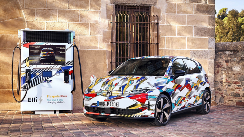Volkswagen ID. Polo mit grafischer Folierung steht an einer Ladestation in historischer Umgebung.