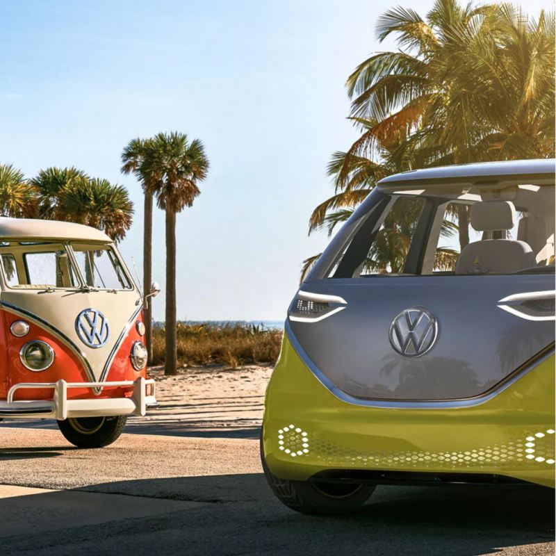 ID.Buzz next to VW camper van at the beach.