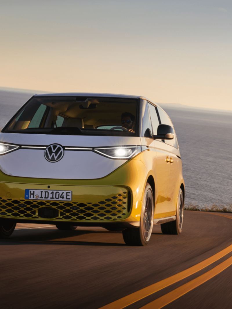 La Volkswagen ID. Buzz jaune conduisant sur la route près de l'océan