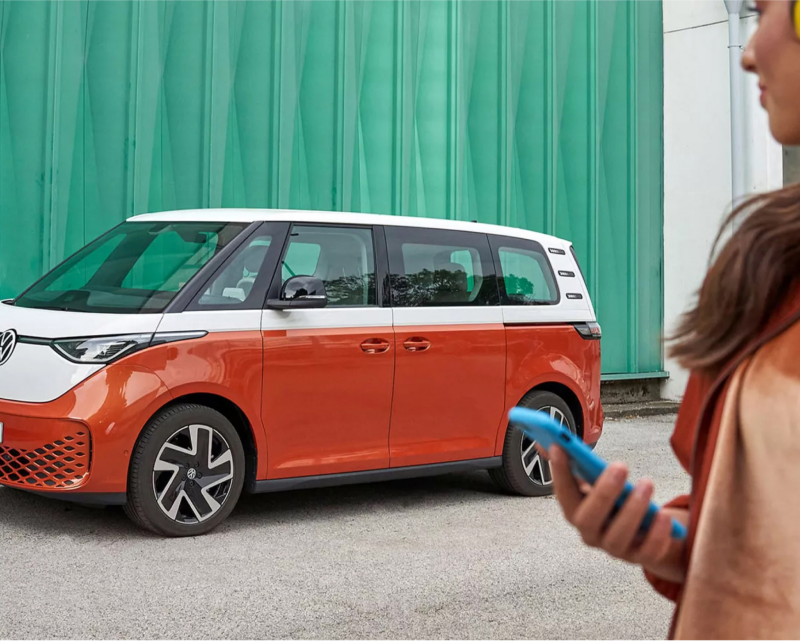 Woman sitting in Volkswagen vehicle using a tablet.