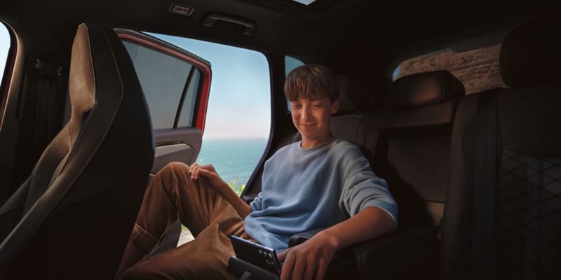 Young man using Wi-Fi hotspot inside VW vehicle.