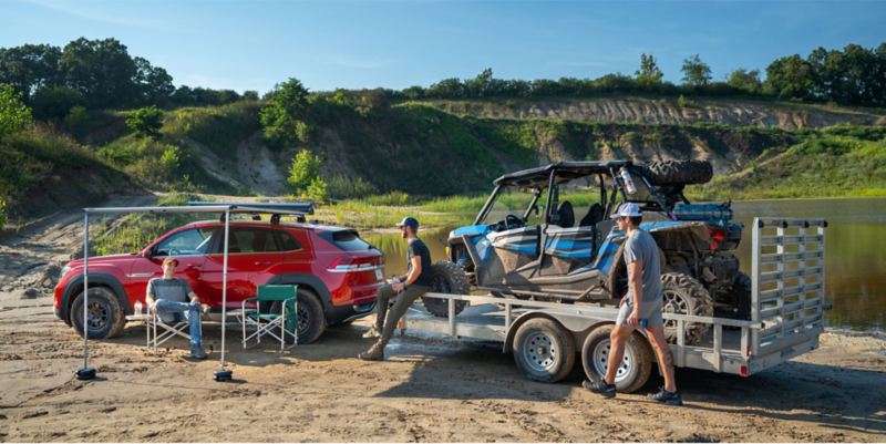 VW Atlas Cross Sport with trailer attached at a camp site.