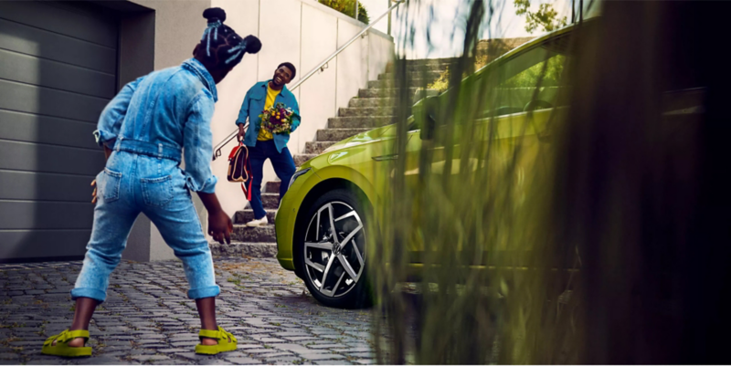 Man and child playing near green Volkswagen. 