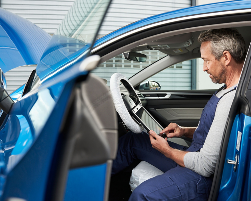 VW certified technician inspecting interior of Volkswagen.