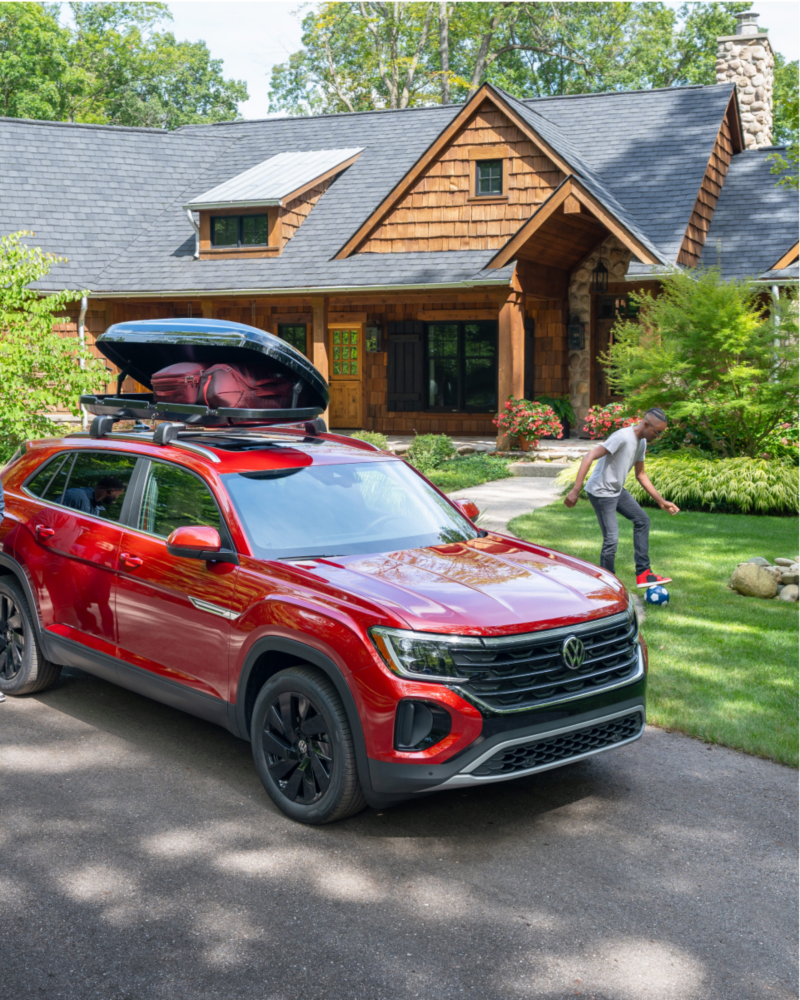 Red VW Atlas Cross Sport parked in front of house.