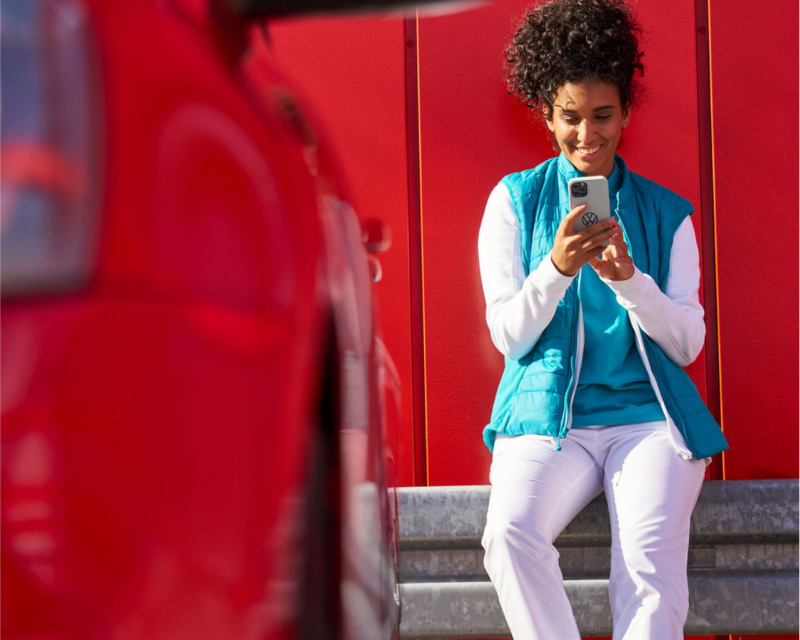 Woman in blue vest using myVW app.