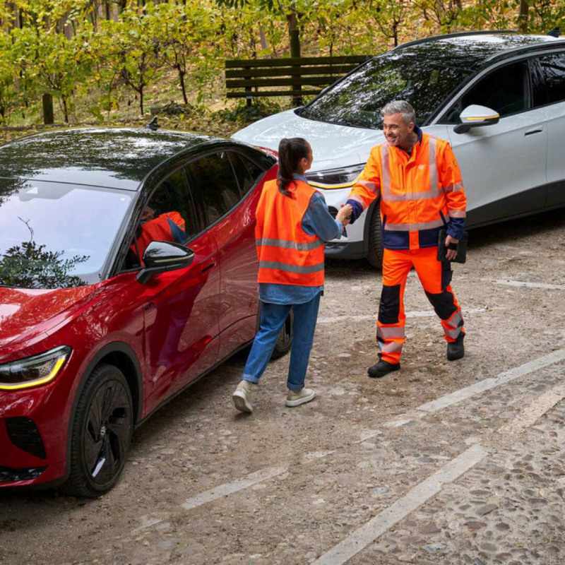 Una mujer y un hombre junto a dos Volkswagen