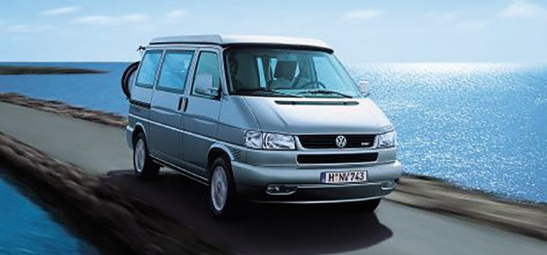 Starsza generacja Volkswagena California na nadmorskiej ulicy. 