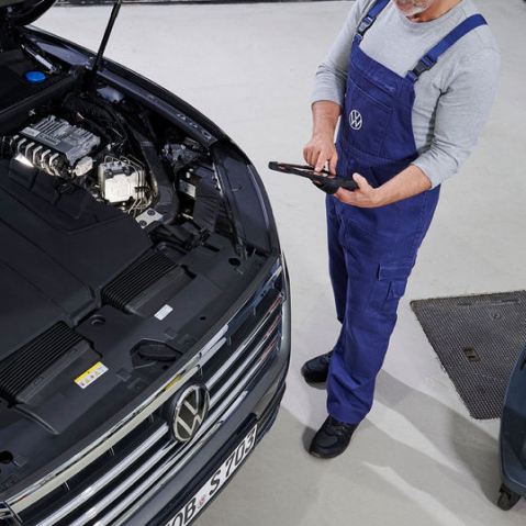 Una agente de servicio Volkswagen delante de un coche