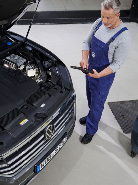 Una agente de servicio Volkswagen delante de un coche